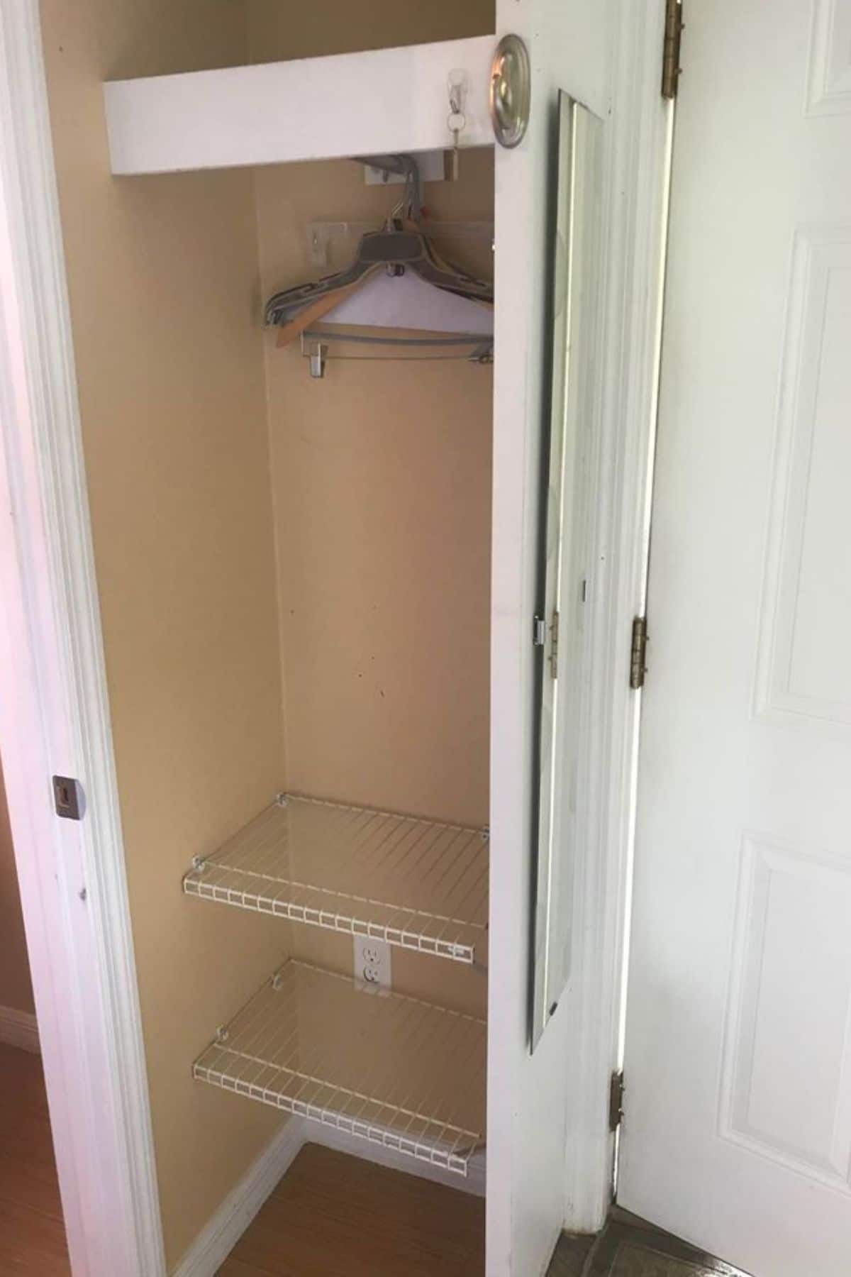 Small closet with white door and brown wall