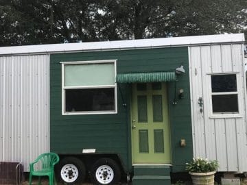 Lime green door on white and green tiny house