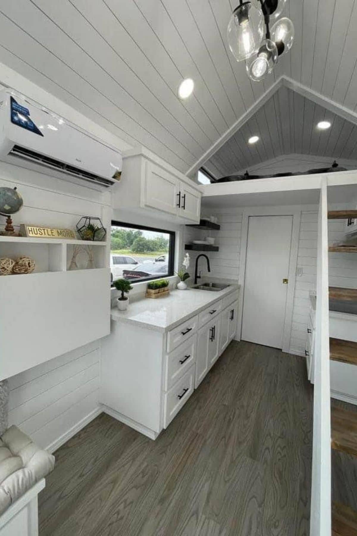 Tiny home kitchen with white cabinets and drop down table