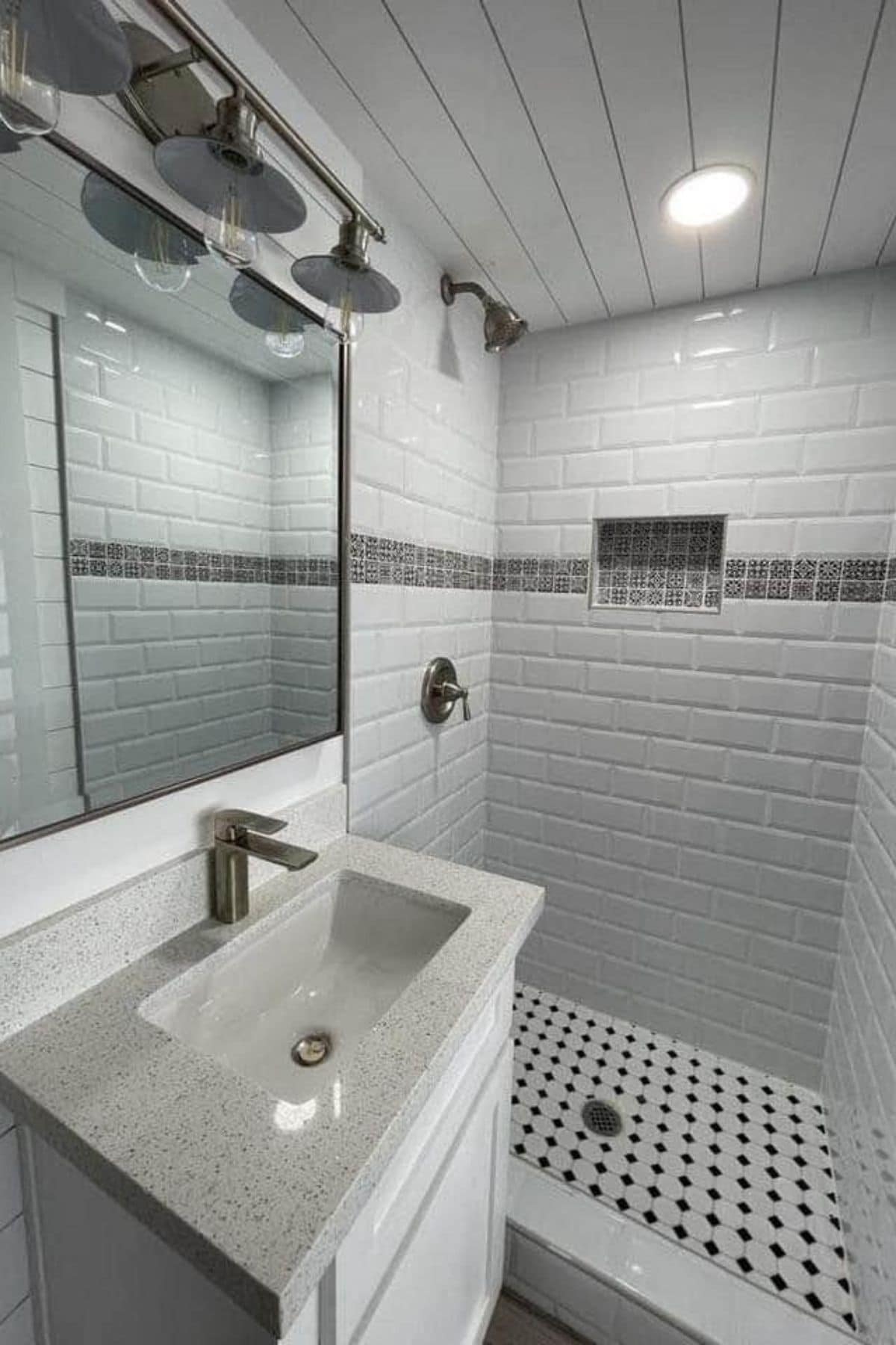 Walk in tiled shower with white and gray tile