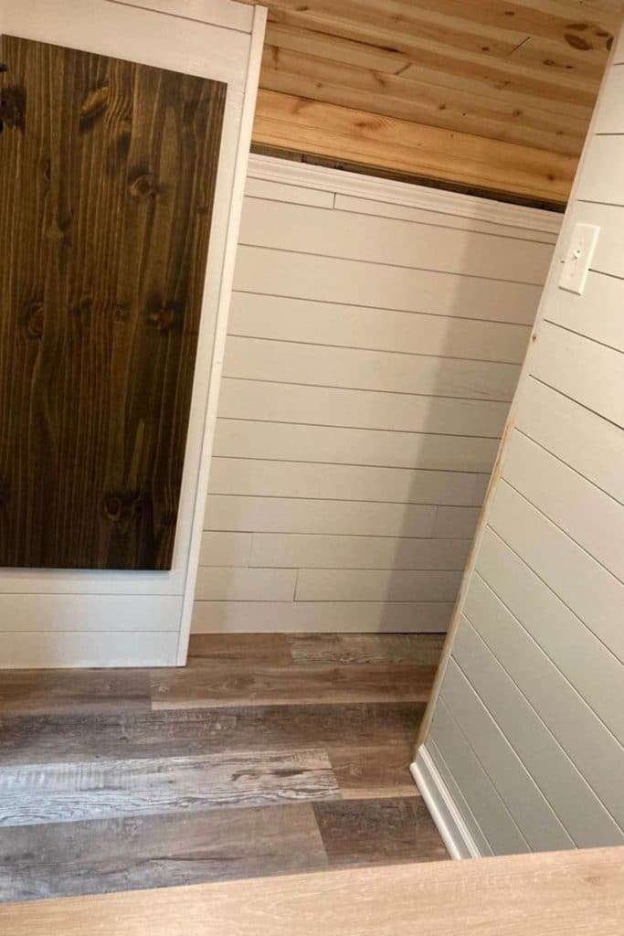 White shiplap walls wood floors and light wood accents in skoolie
