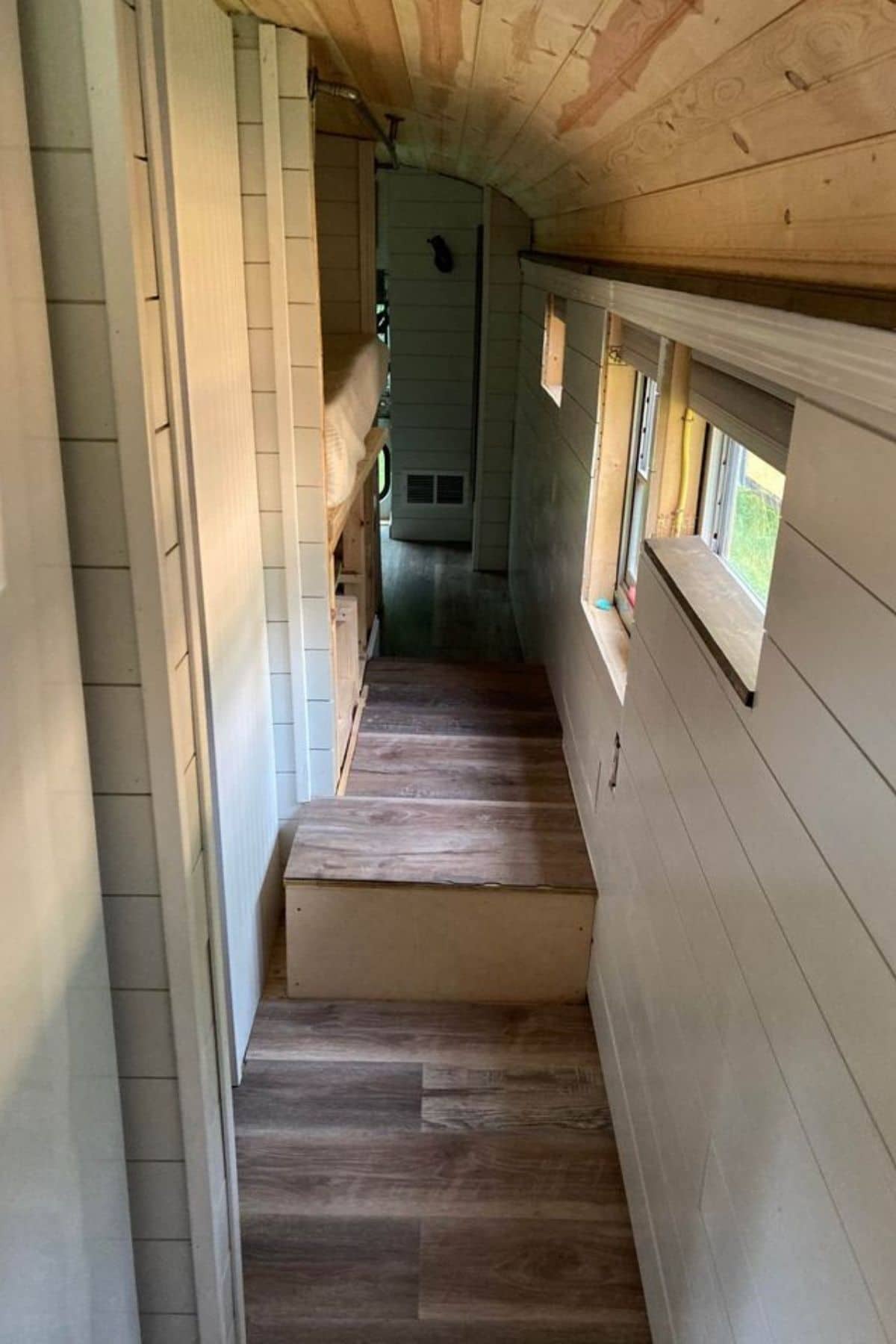 Hall in bus with shiplap walls and wood floor