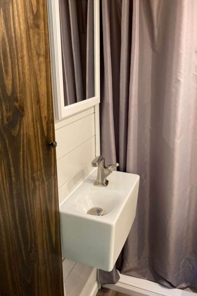 Mini sink under mirror against shiplap wall