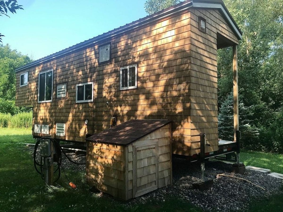 Back side of wood sided tiny home with white trim