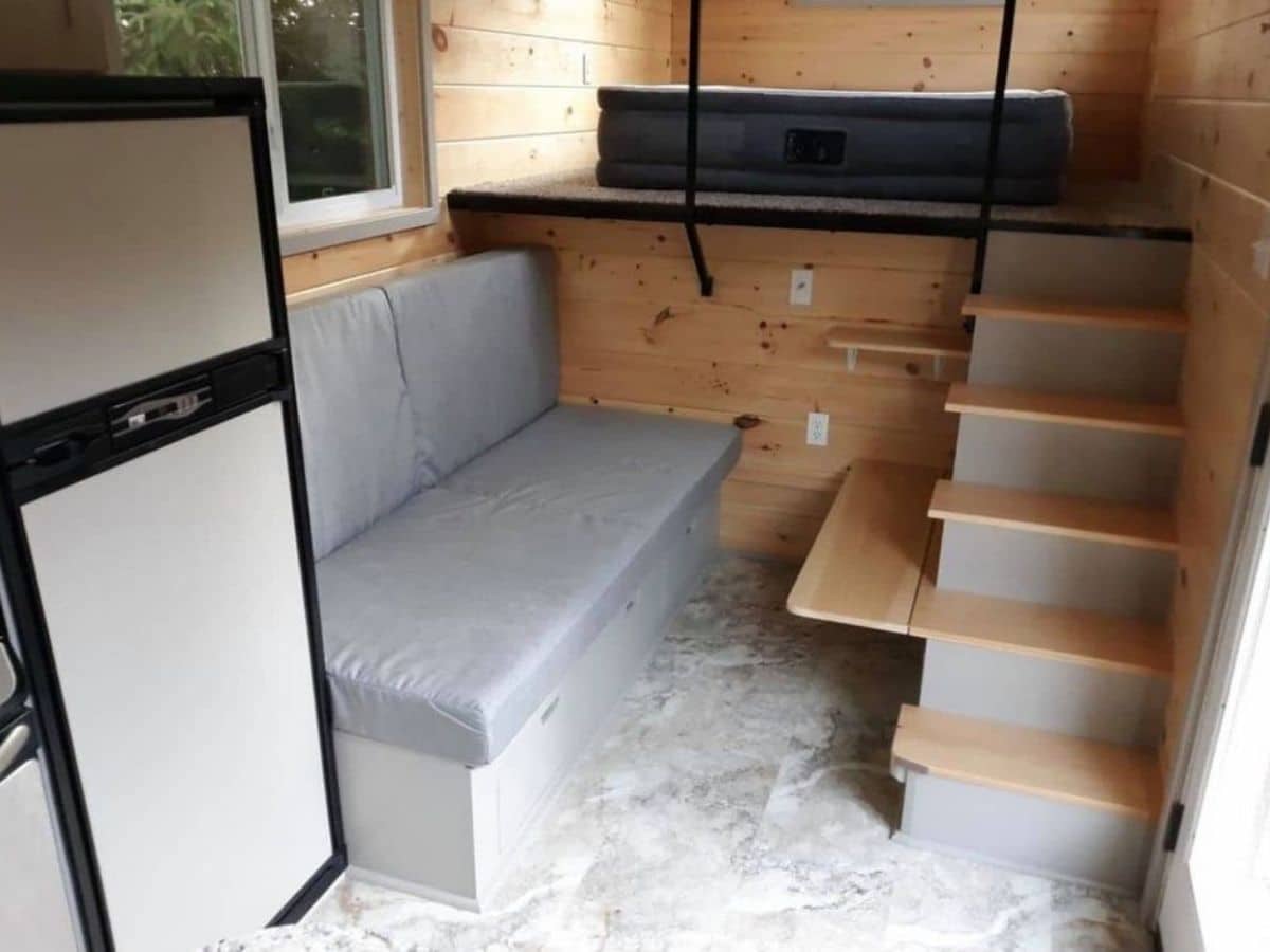 Sofa bench next to stairs and refrigerator by loft