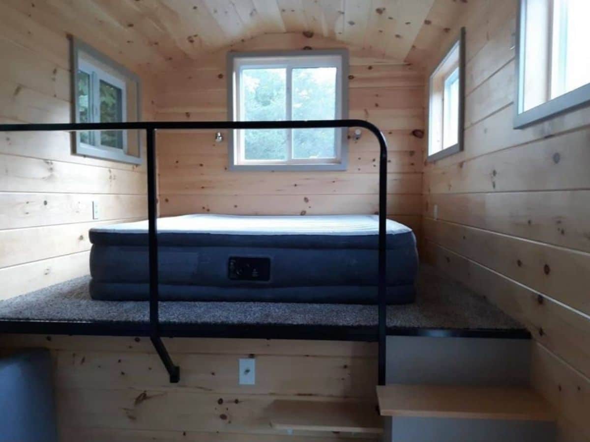 Air mattress in tiny loft space with black matte railing