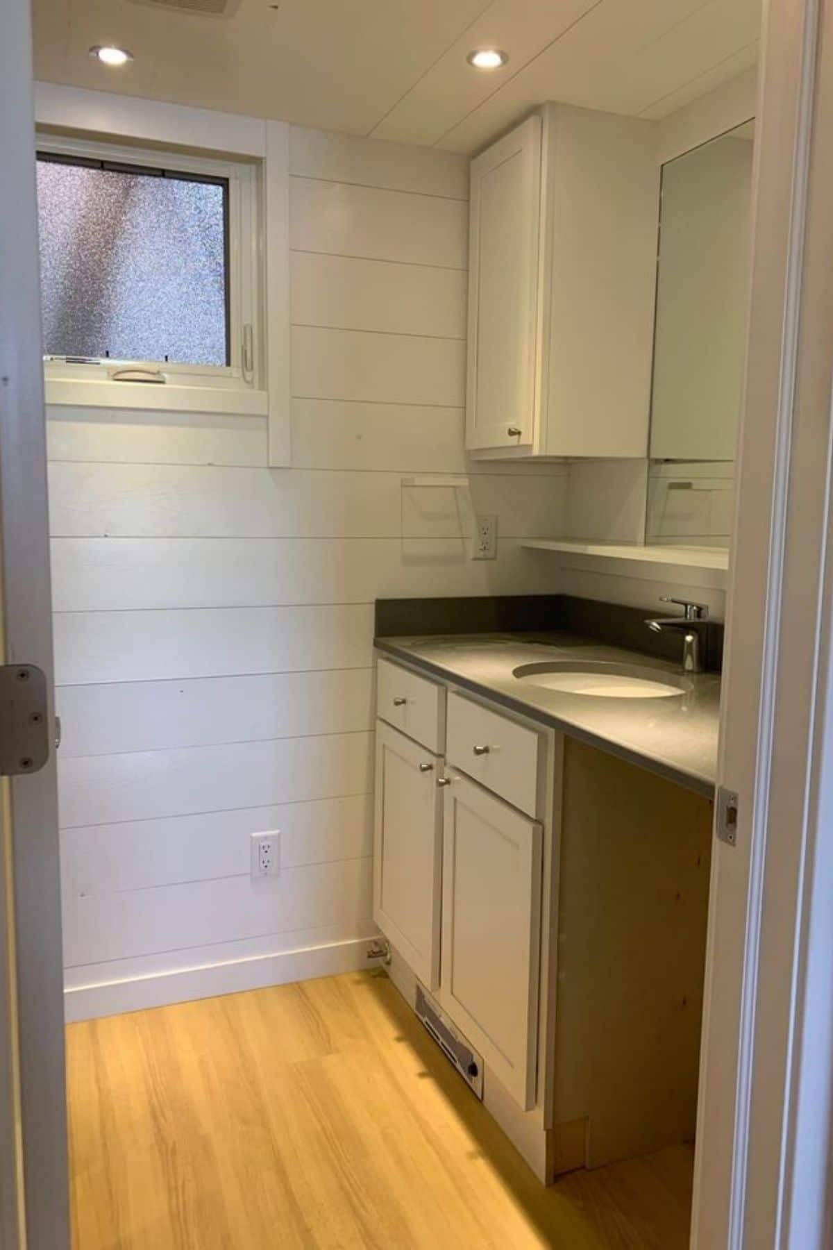 Empty bathroom with two cabinets and opening under sink