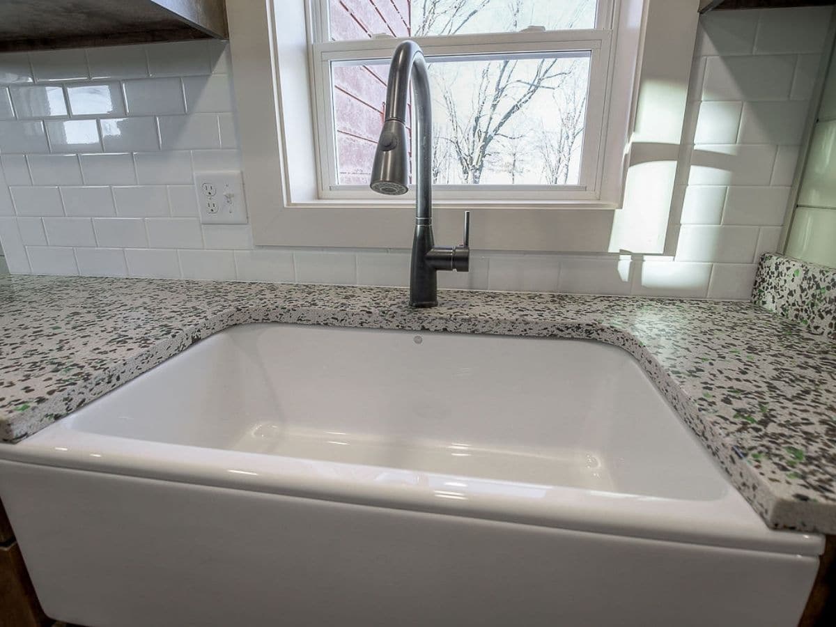 Deep white sink with silver faucet under window