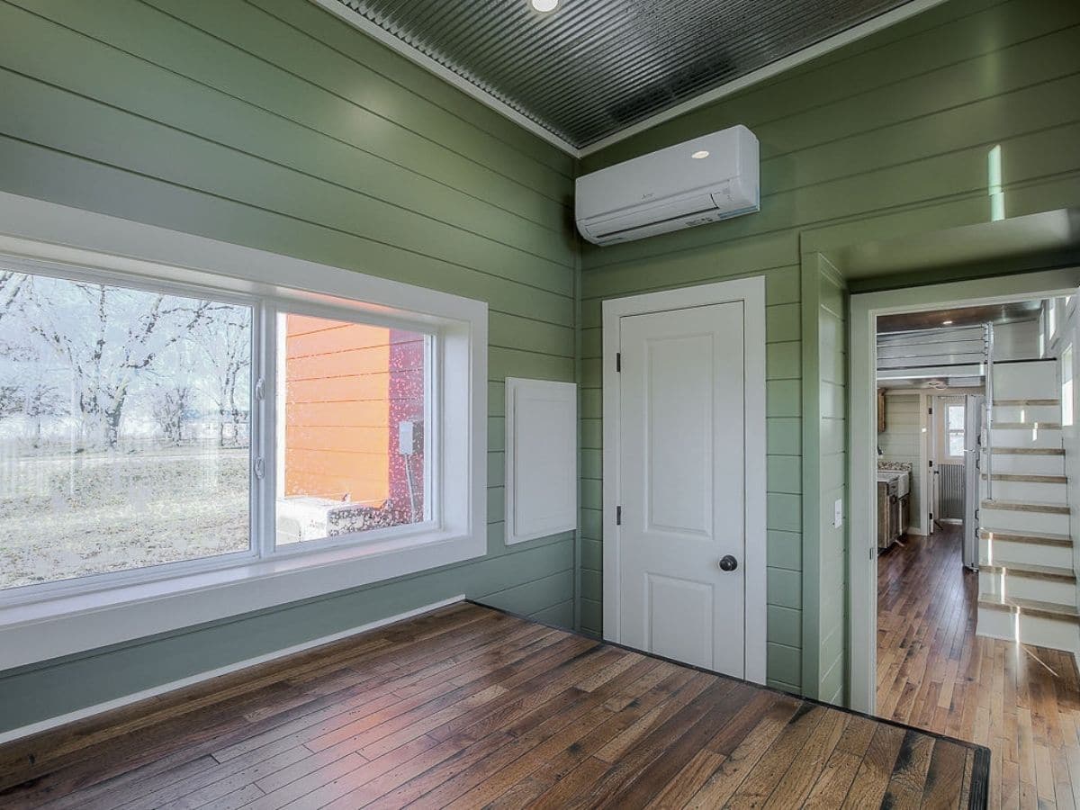 Green walls with wood floor next to long window