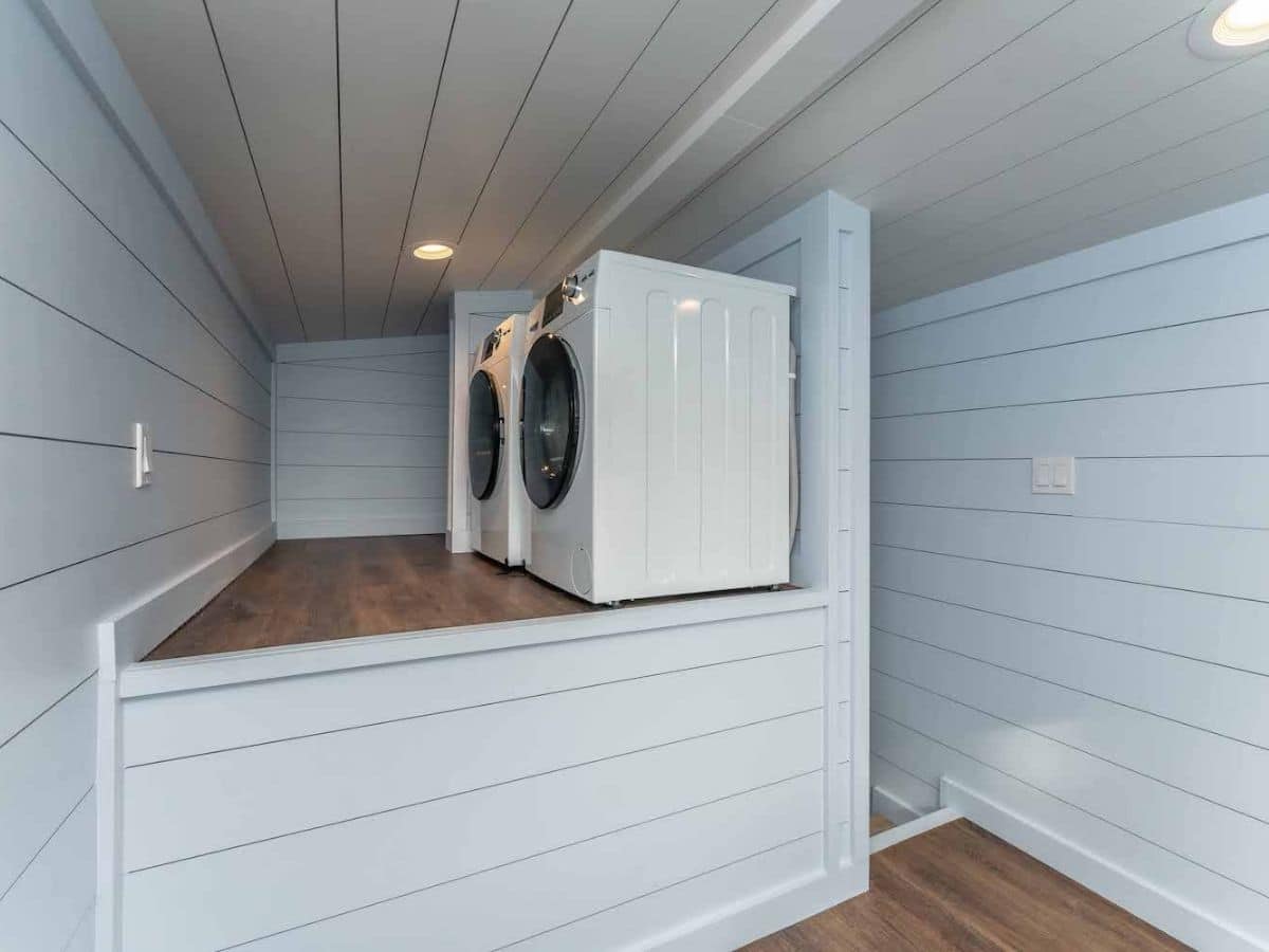 Washer and dryer in loft space with wood floors