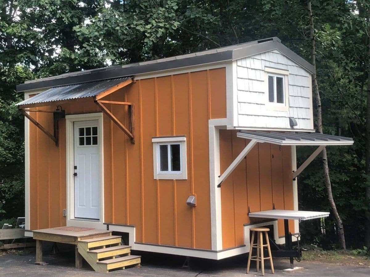 Orange and white tiny home with awning over door