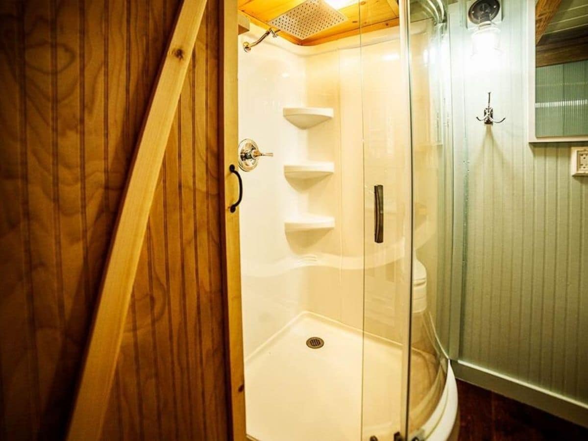 Wood door leading into bathroom with corner shower
