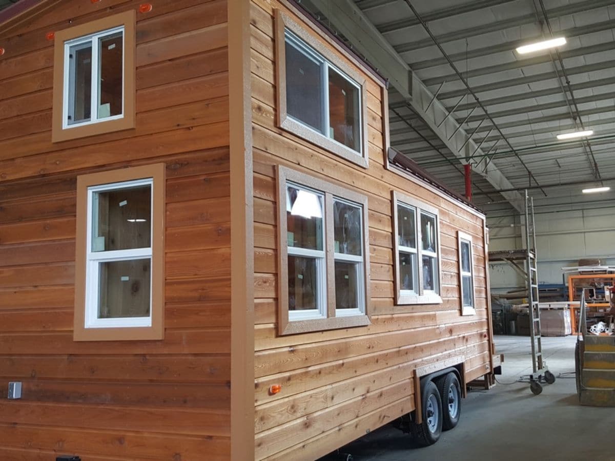 Wood siding and white windows on tiny house in garage