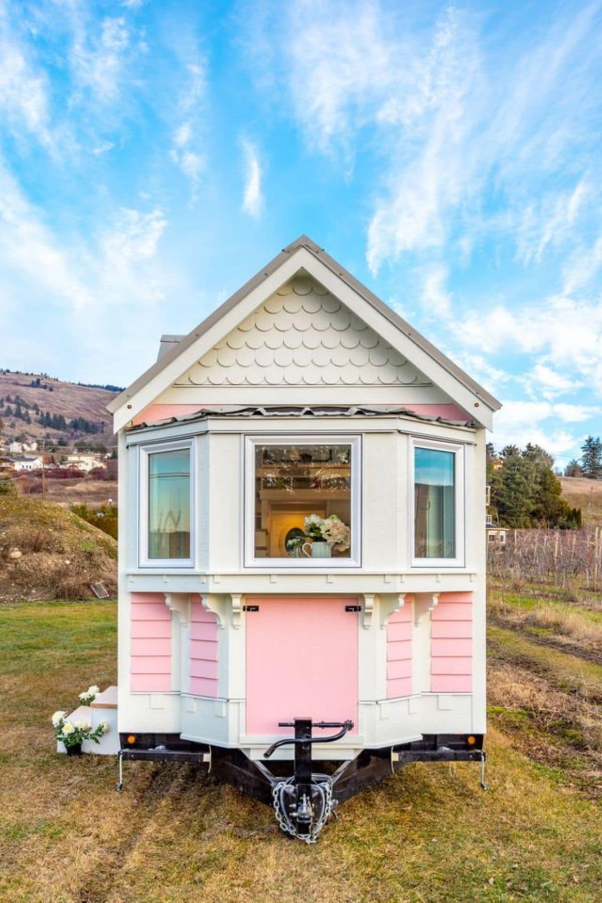 Pink and white tiny home with blue sky background
