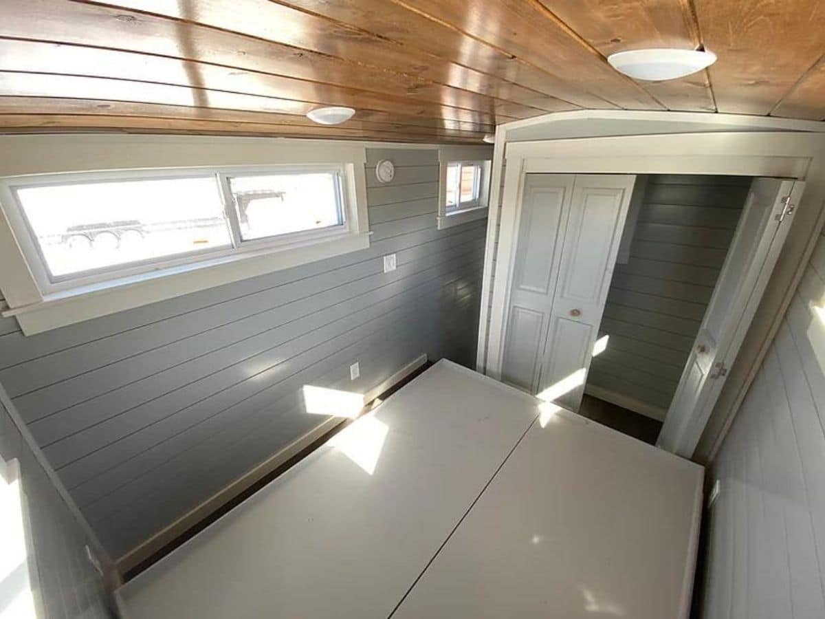 View looking out of tiny home bedroom with elevated bed