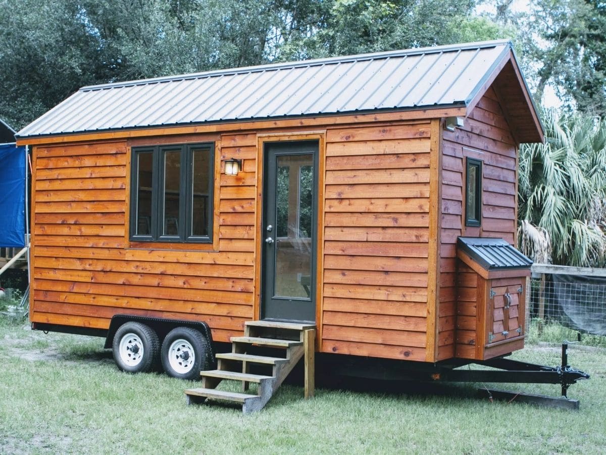Wood siding on small tiny home on wheels in lot
