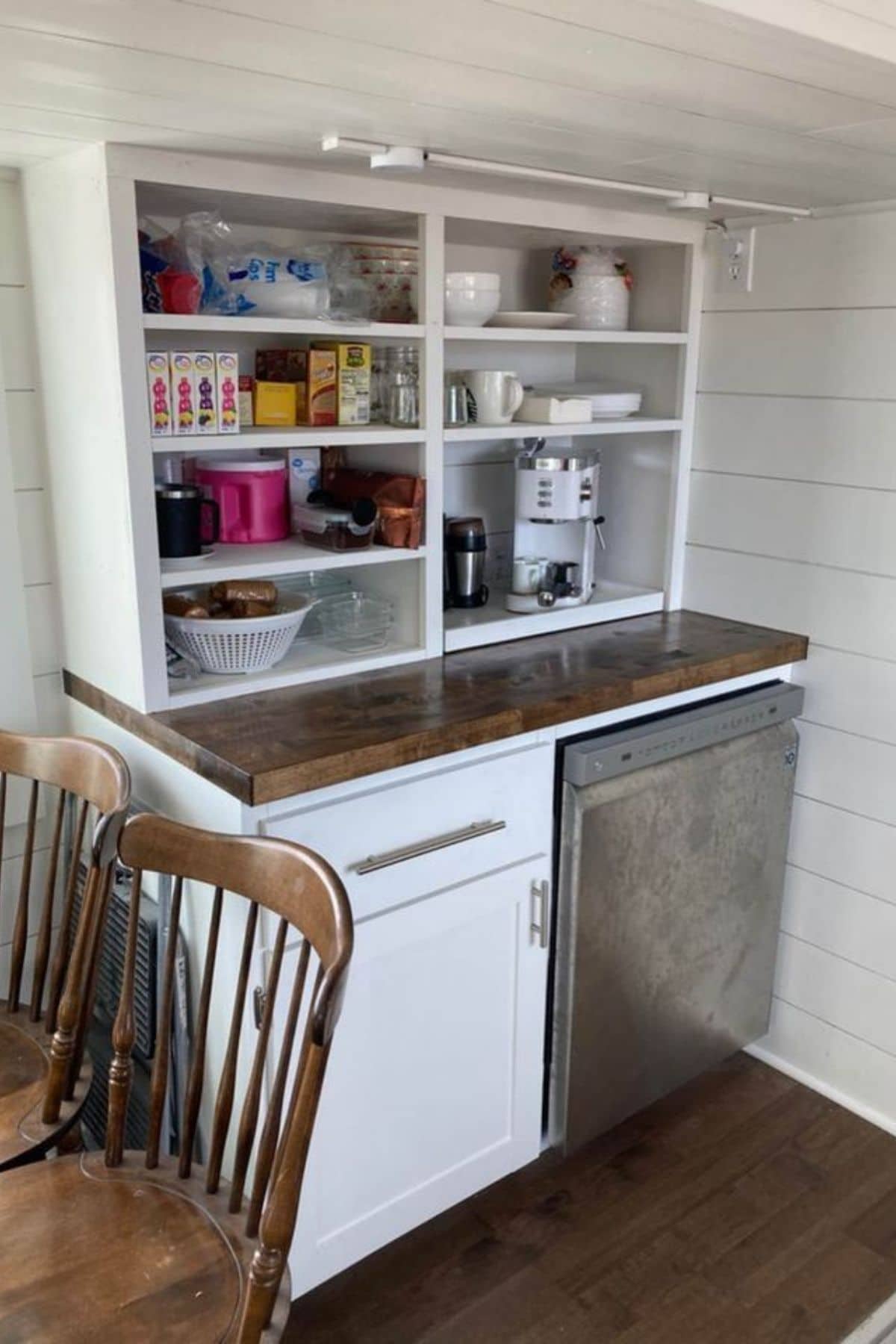 Stainless steel dishwasher under cabinet with open shelves above