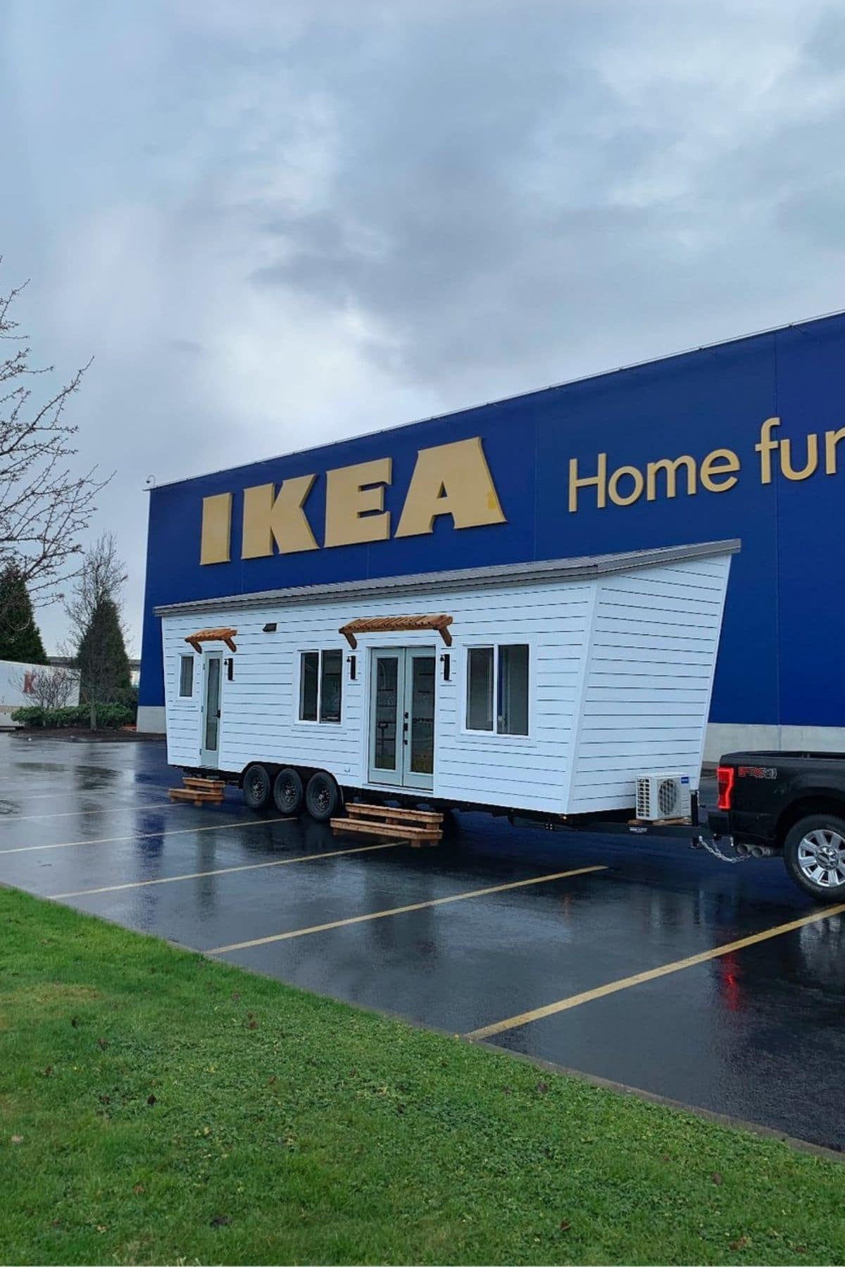 White tiny home with truck in Ikea parking lot