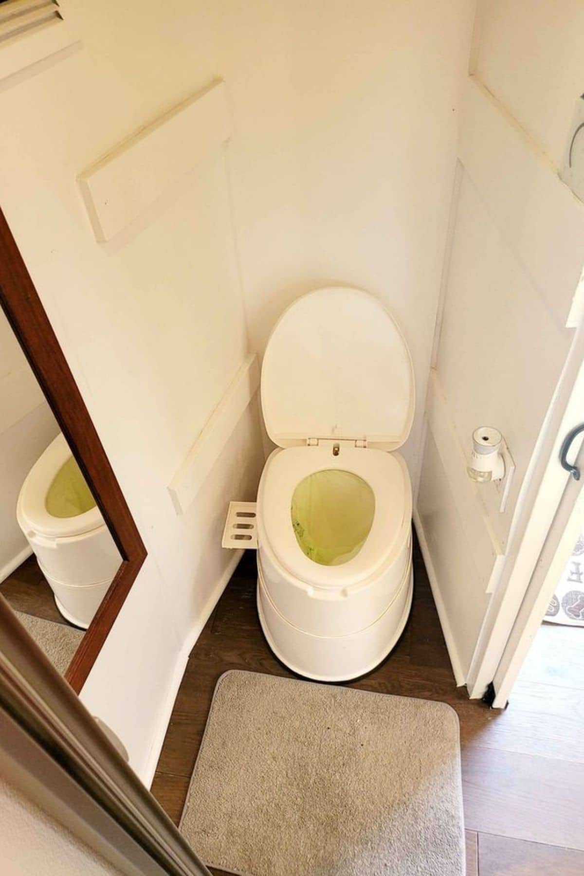 Composting toilet by white walls