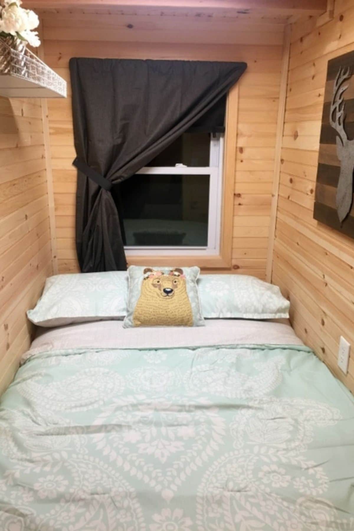 bed in tiny room with black curtains