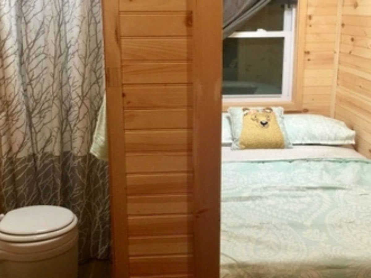 bathroom on left and bedroom on right with wood wall between