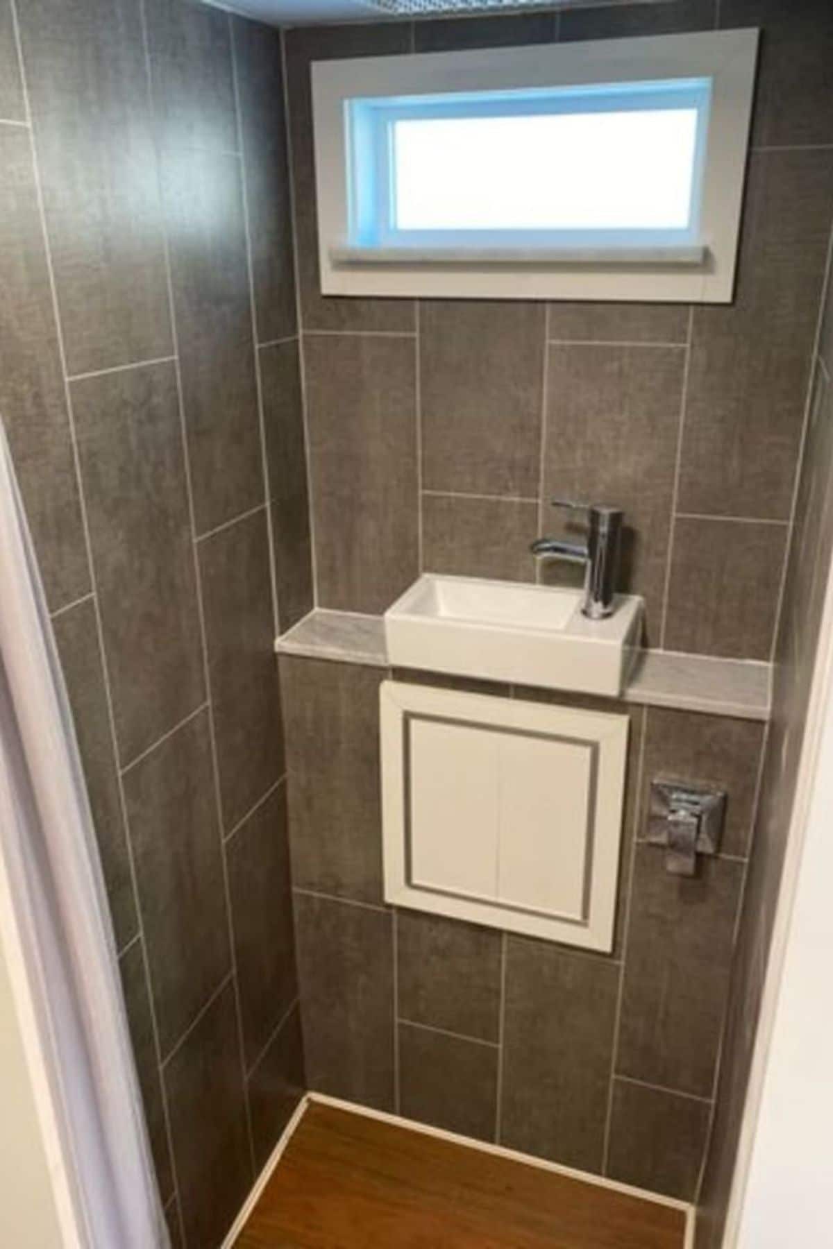 gray tile wall in shower with sink in shower