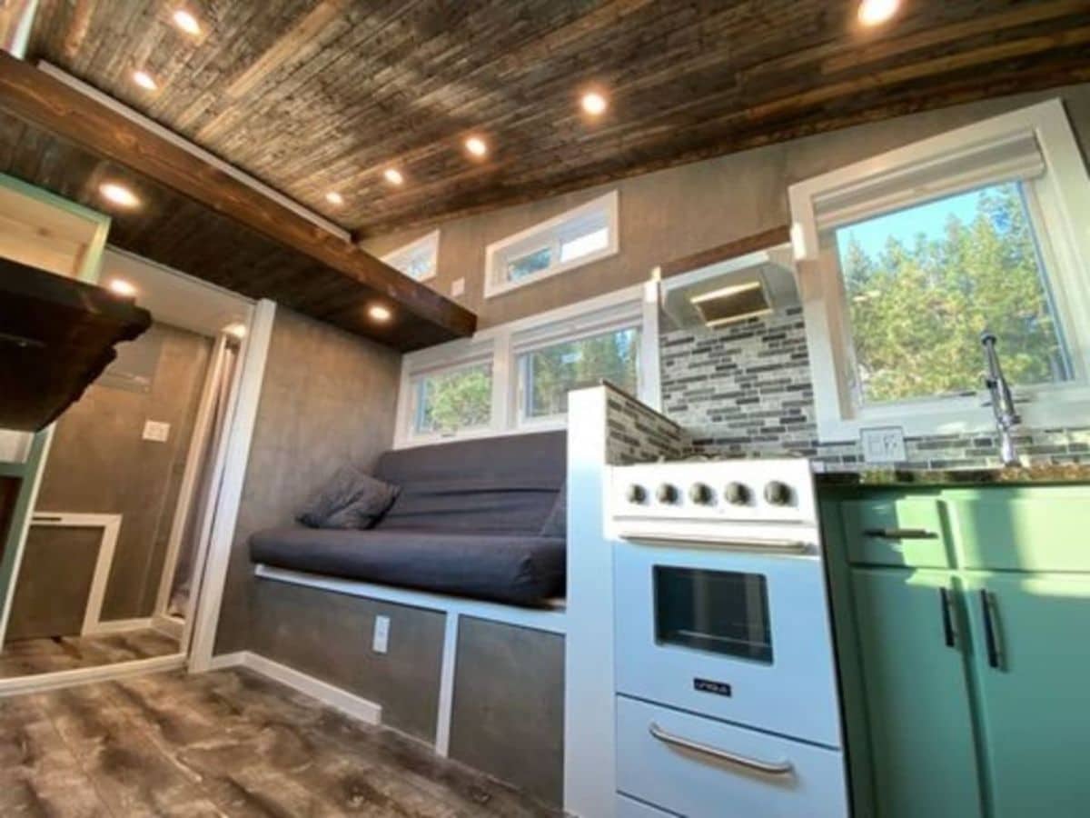 white stove against green cabinets inside tiny home