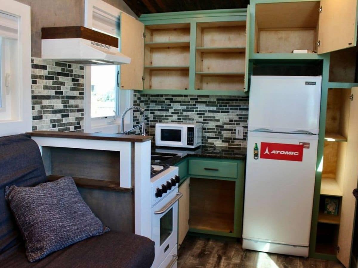 open kitchen cabinets with green trim and white appliances