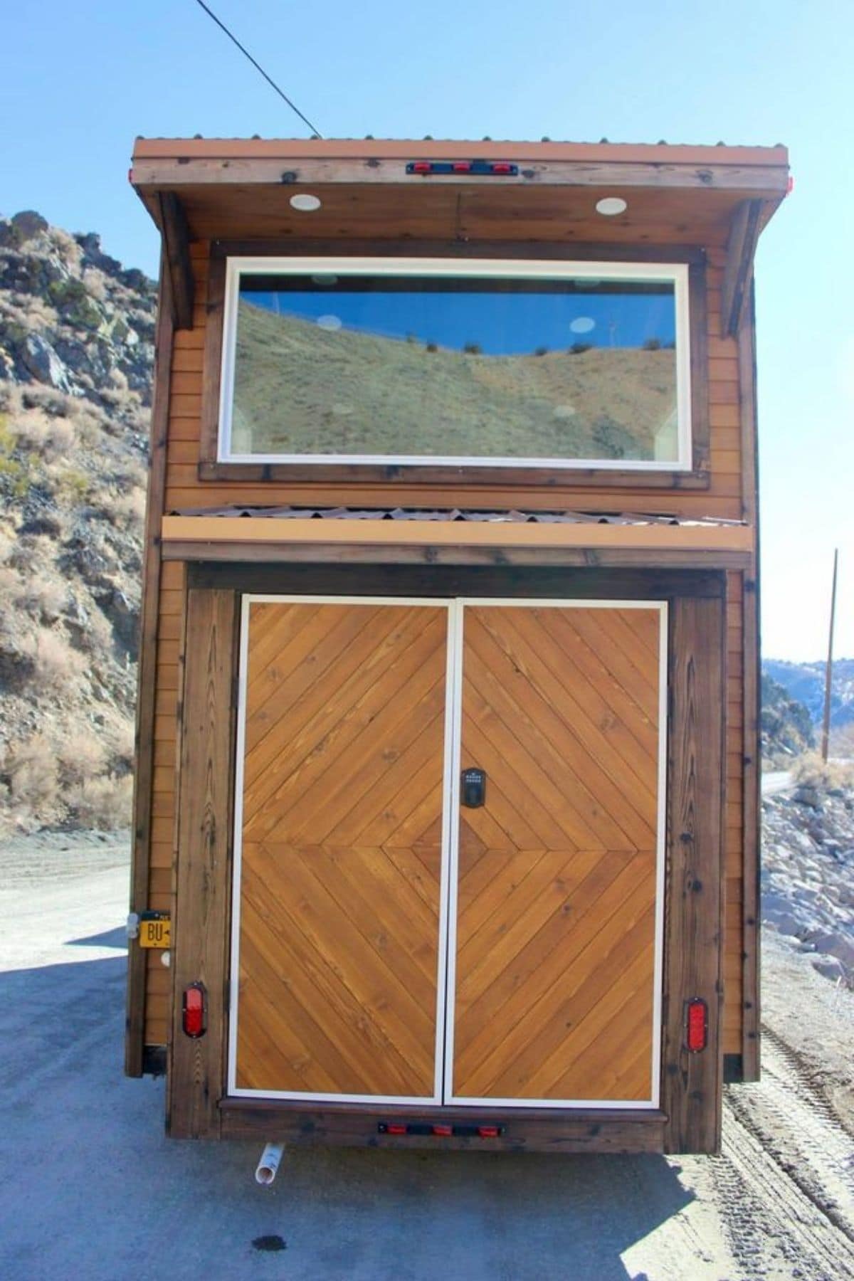 back of tiny home with door for exterior storage