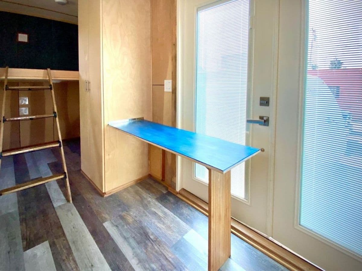 Teal and wood drop down table by doors