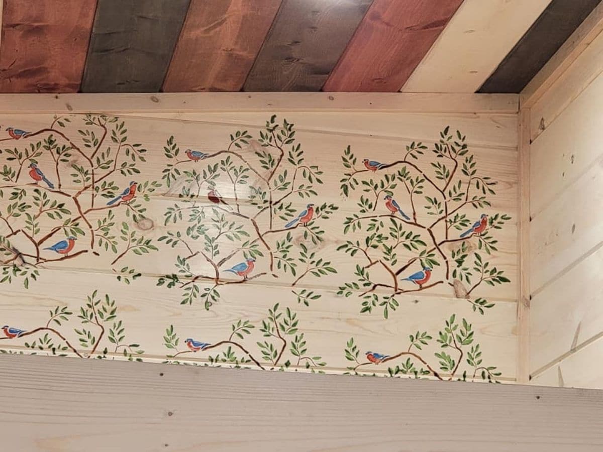 floral vine and bird painting on wall in tiny home