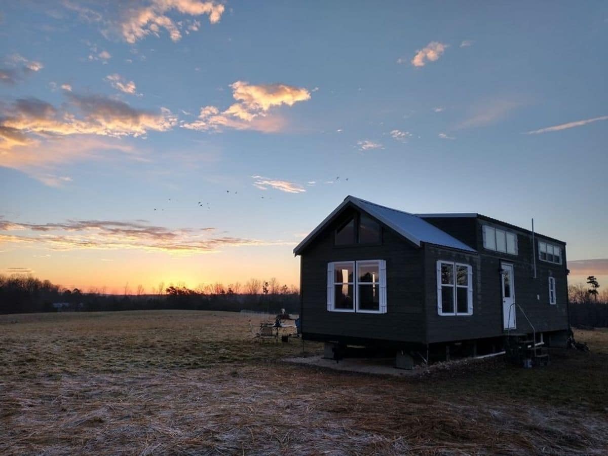 Dark tiny home after sunset against blue sky