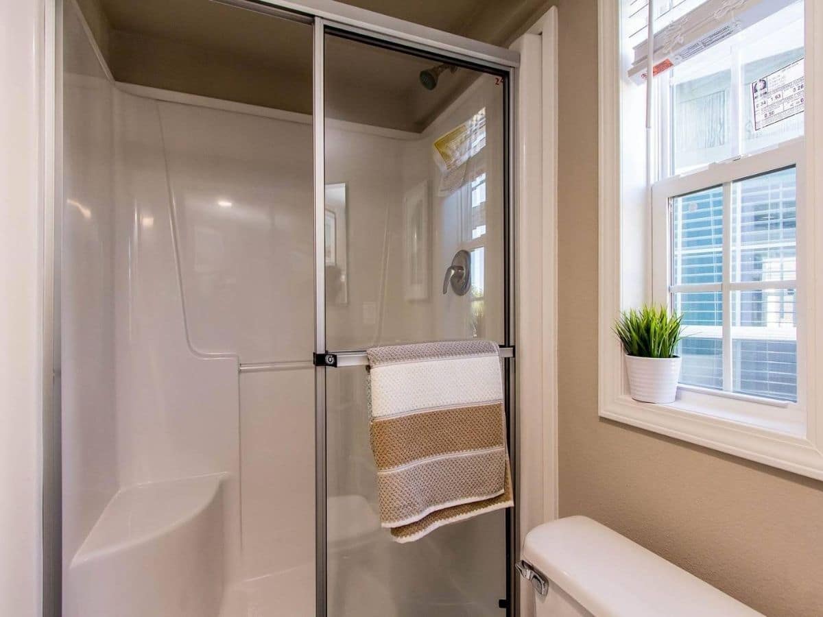 glass shower door on white shower by toilet