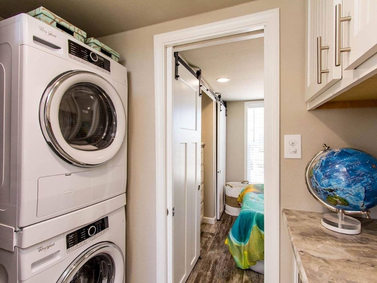 stacking washer and dryer on left by open door to bedroom