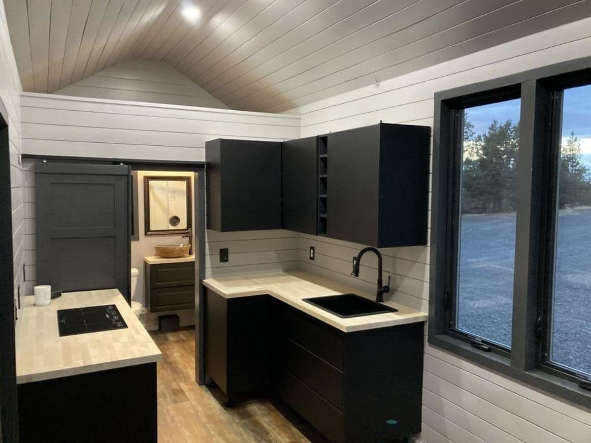 black cabinets under white counter in tiny home kitchen