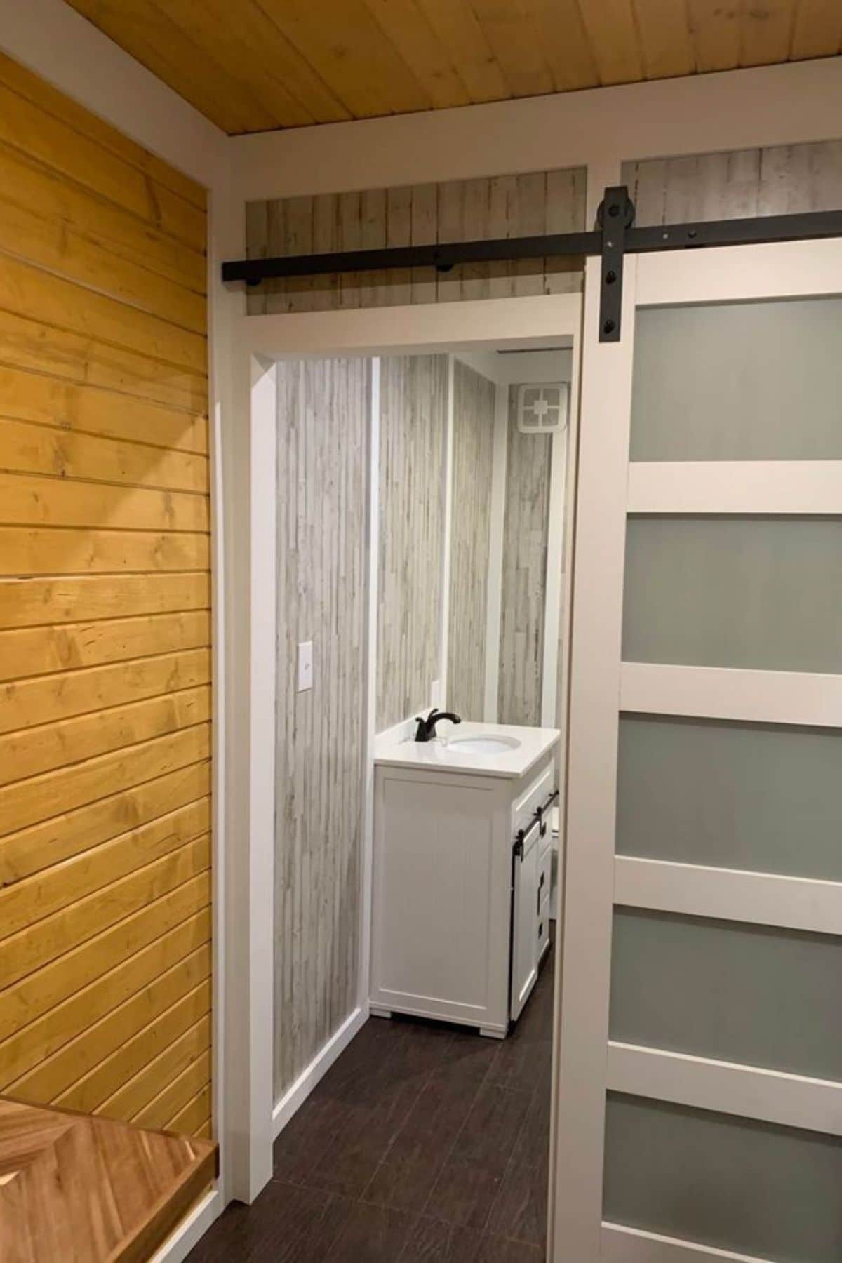 gray and white barn door by bathroom door opening