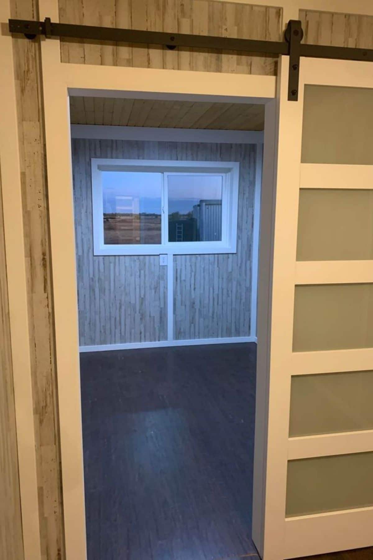 view into tiny bedroom with window on end