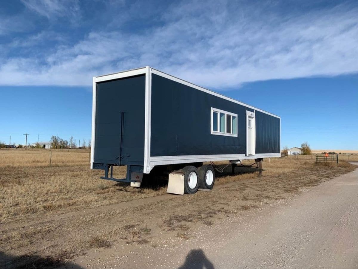 back side of blue and white semi trailer tiny home