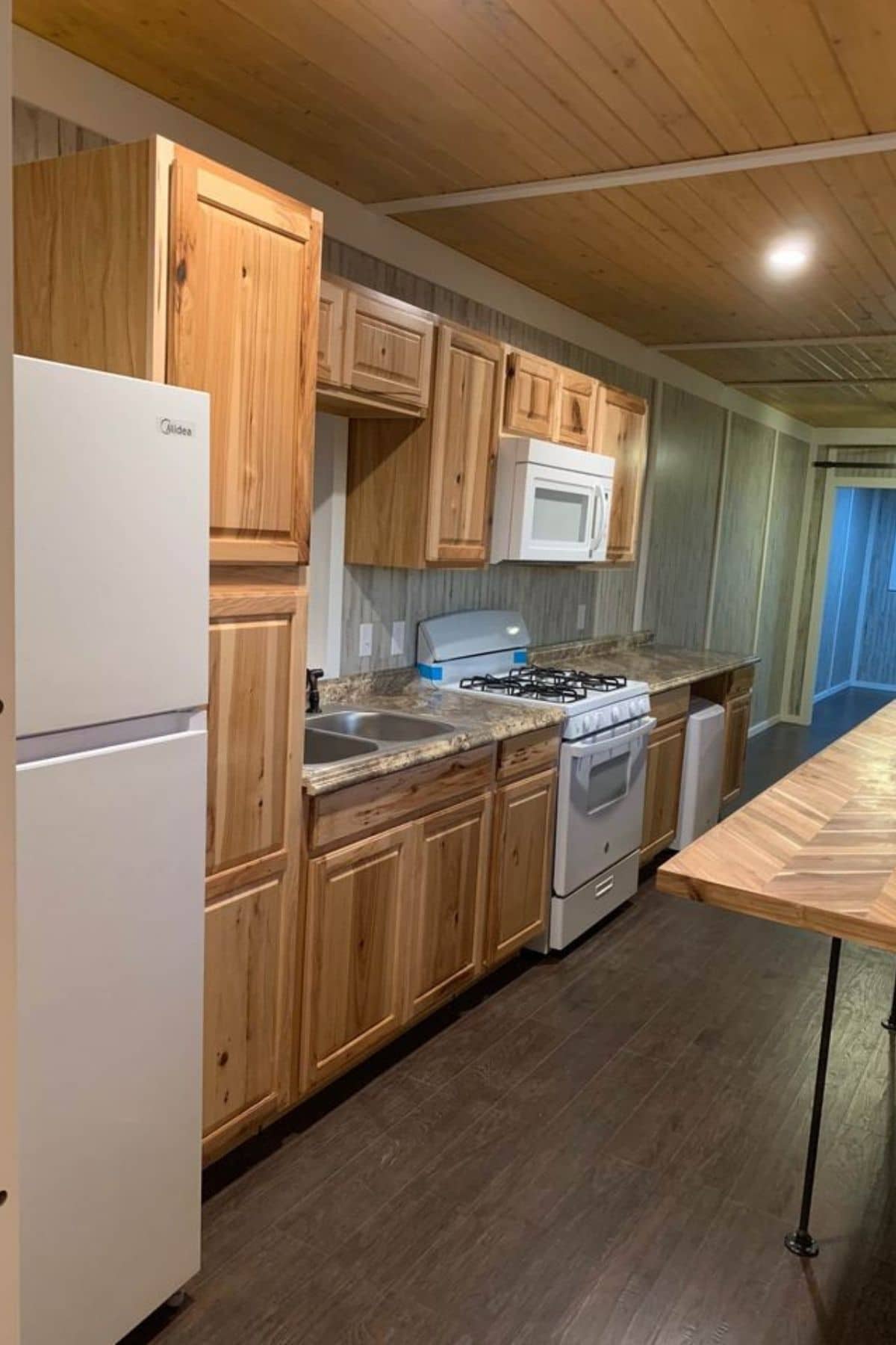 white refrigerator against wood cabinets in tiny home
