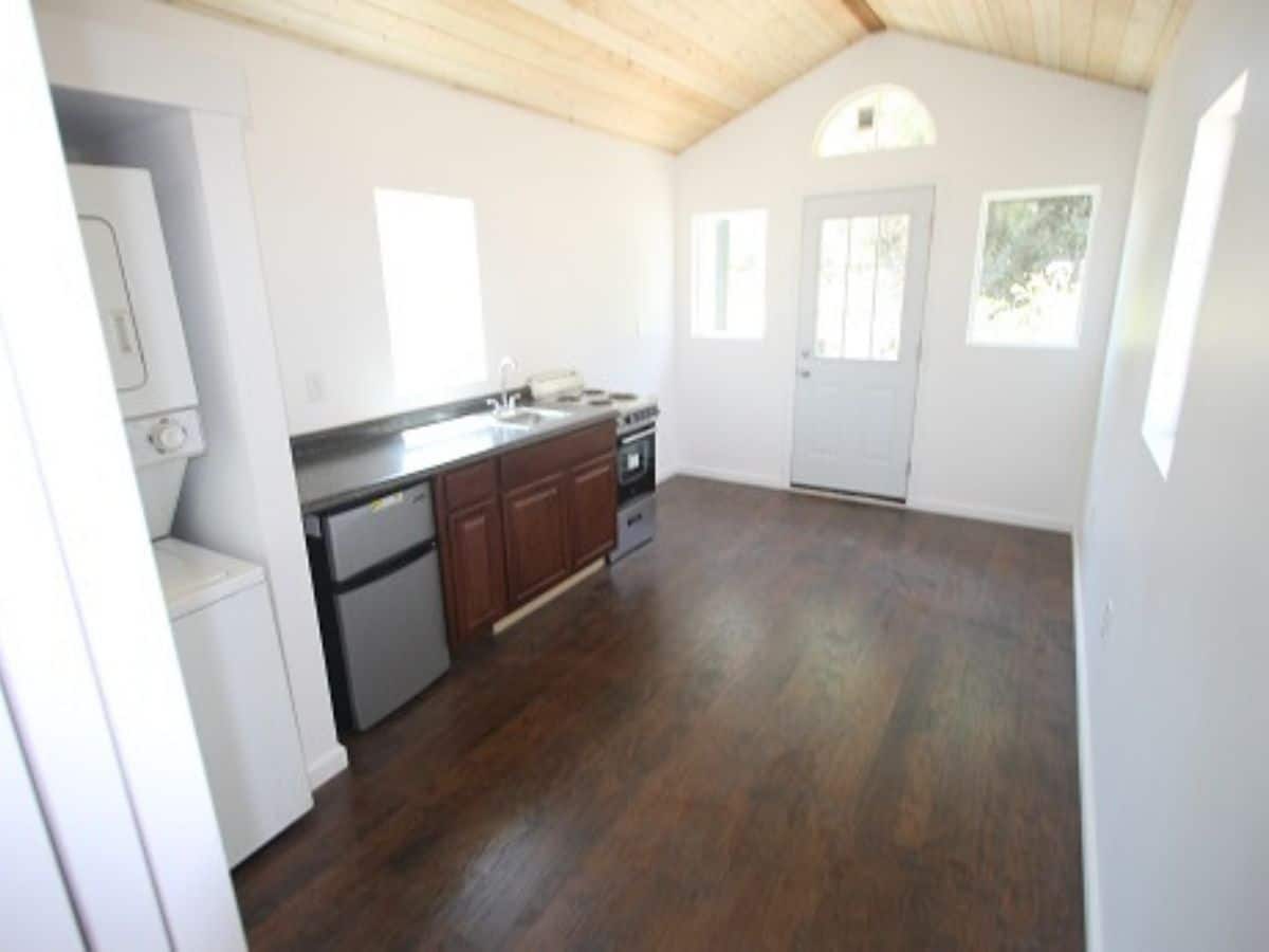 kitchen counter on left and door at back of tiny home