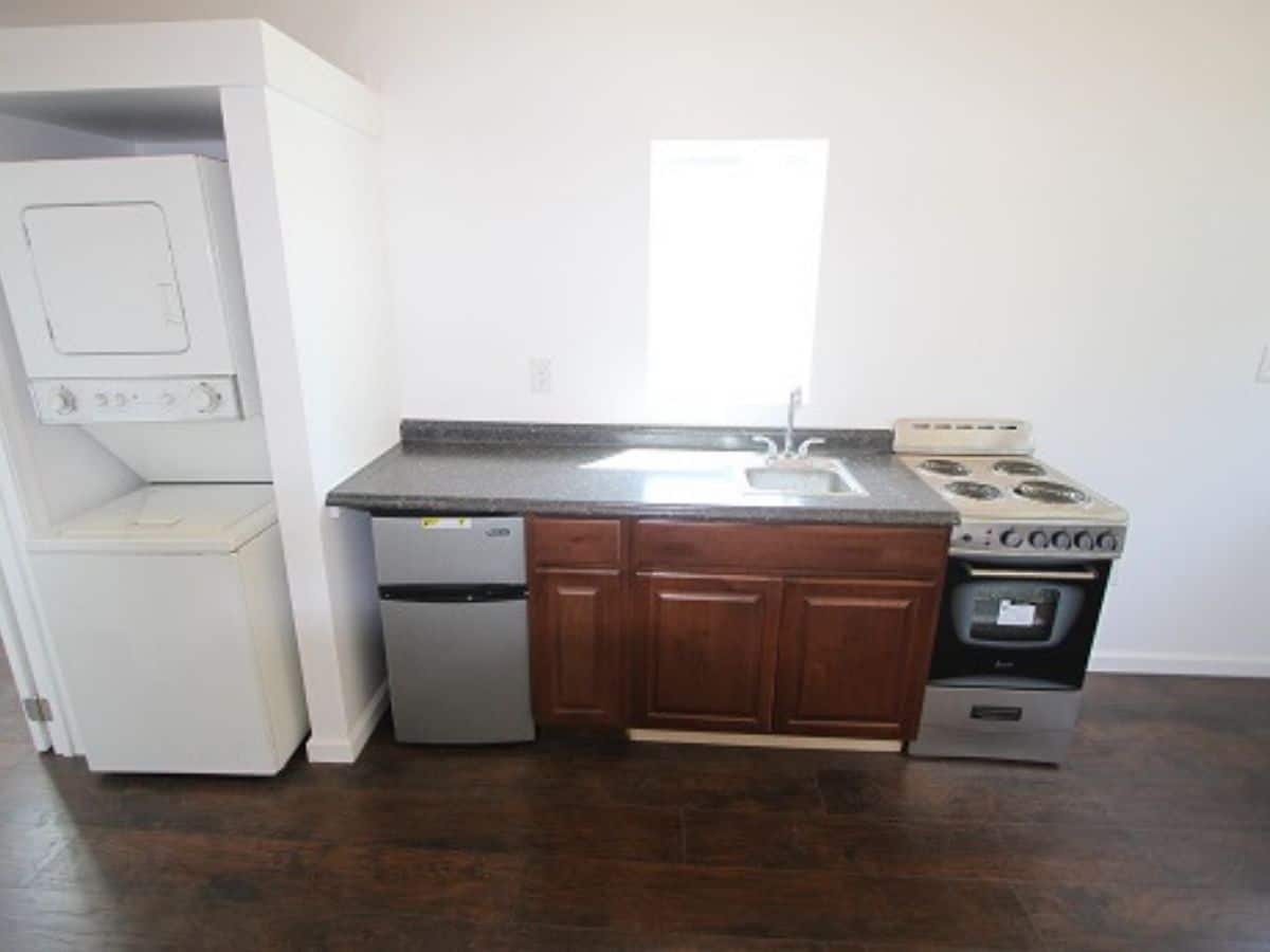 kitchen counter with stainless steel stove and refrigerator against white wall