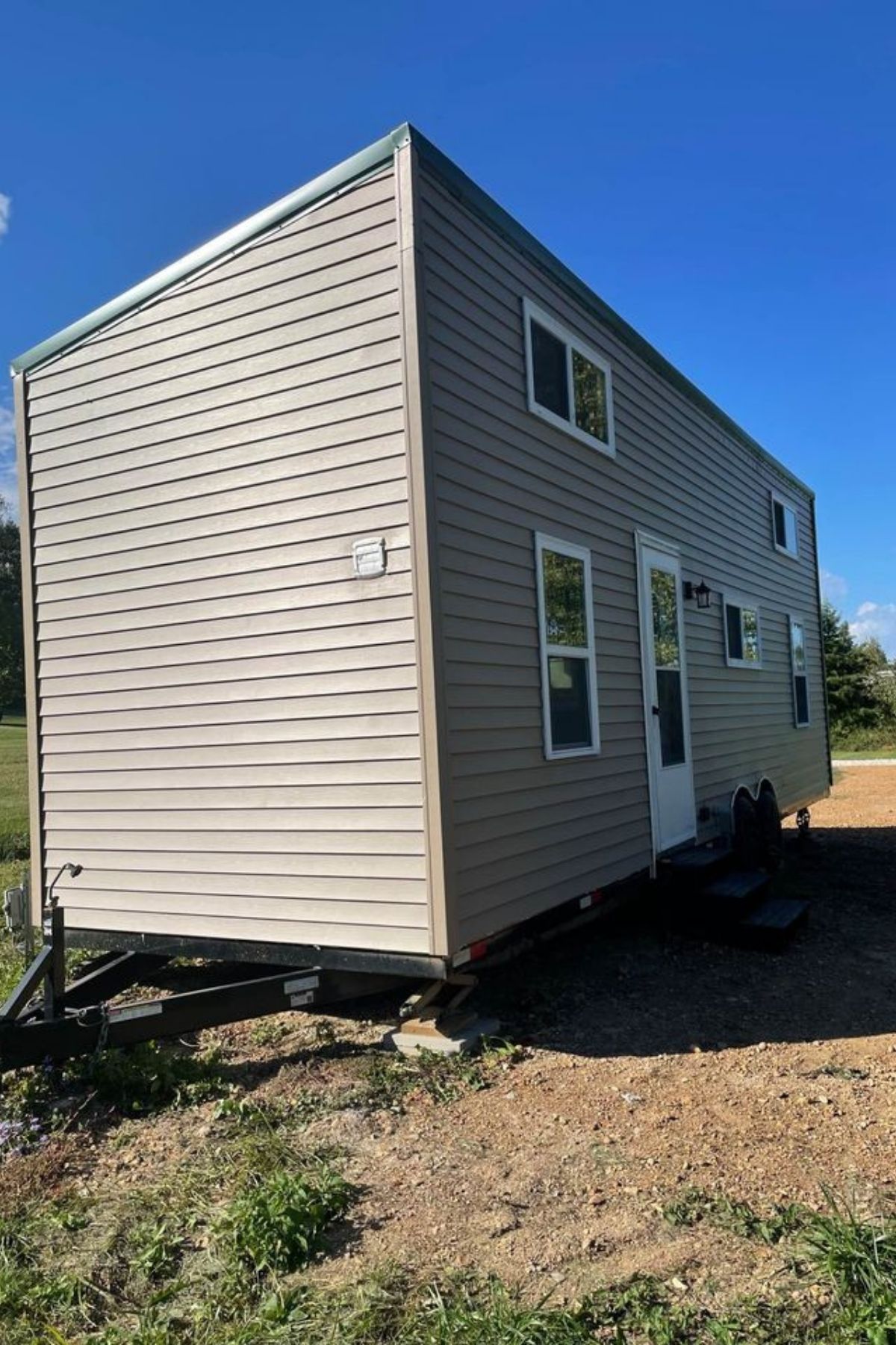 tiny home with cream siding on grass lot