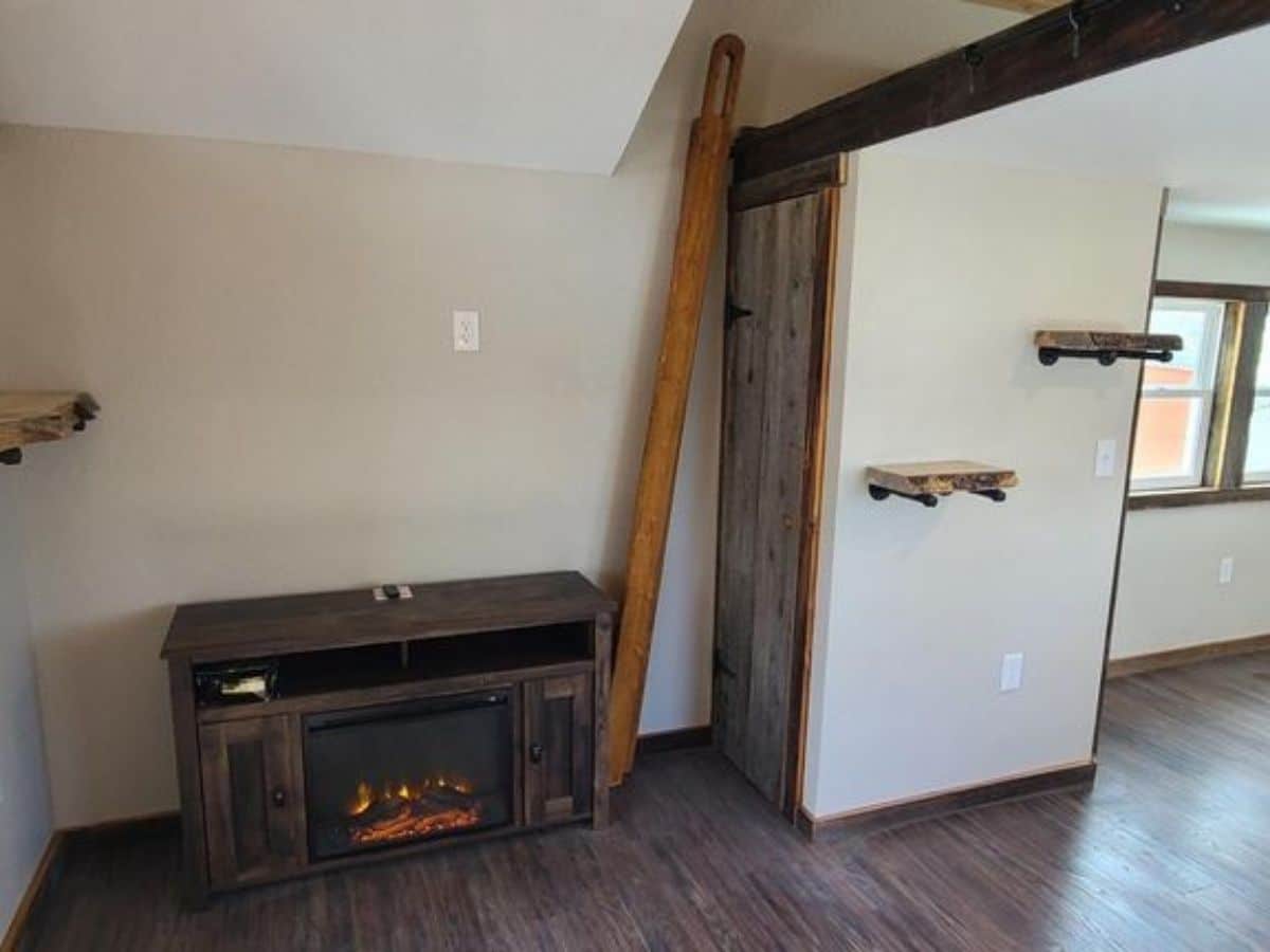 fireplace against wall by ladder to loft