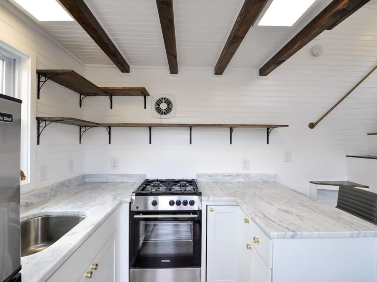 gas stove in center of white cabinets in tiny home