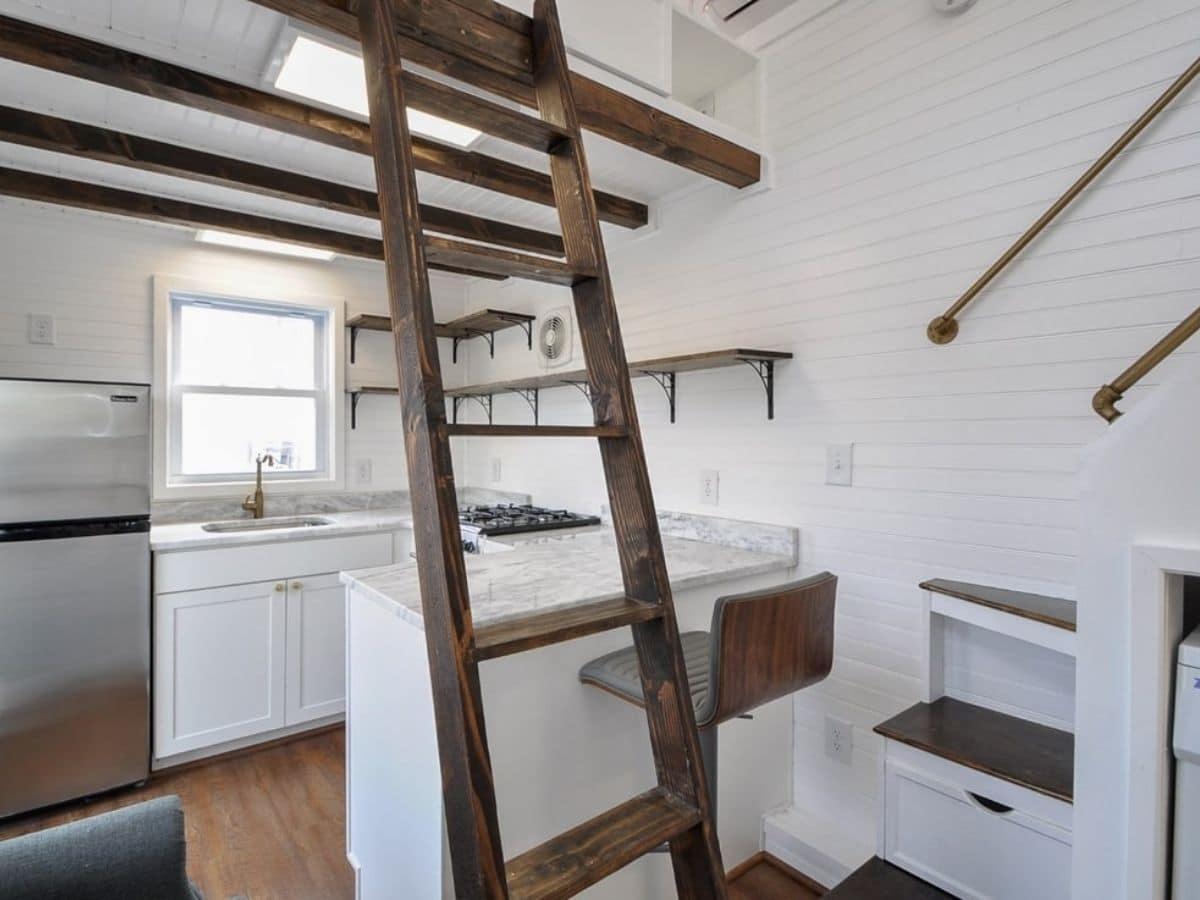ladder by white cabinets with stool