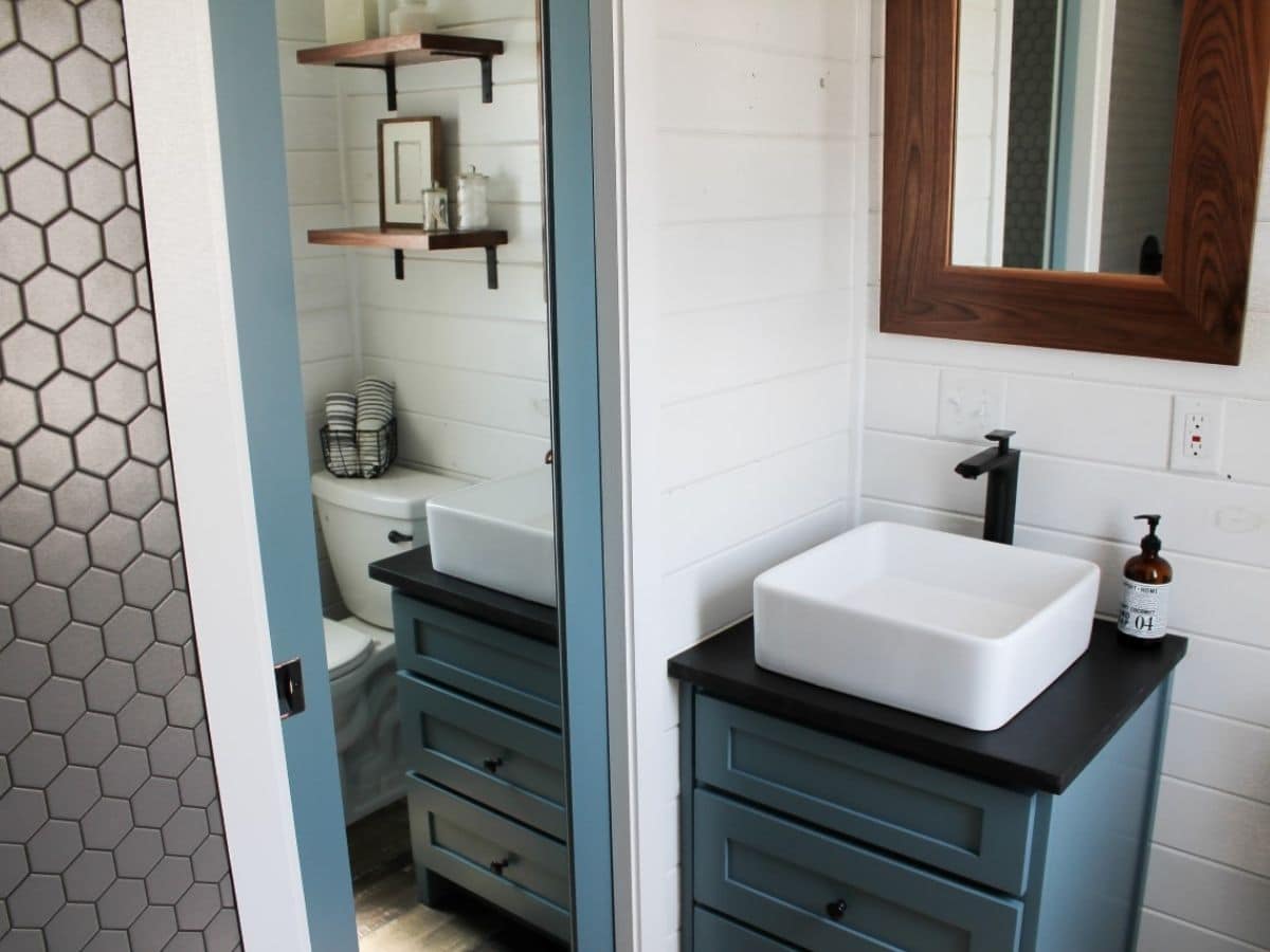 teal vanity with white bowl sink against door with mirror
