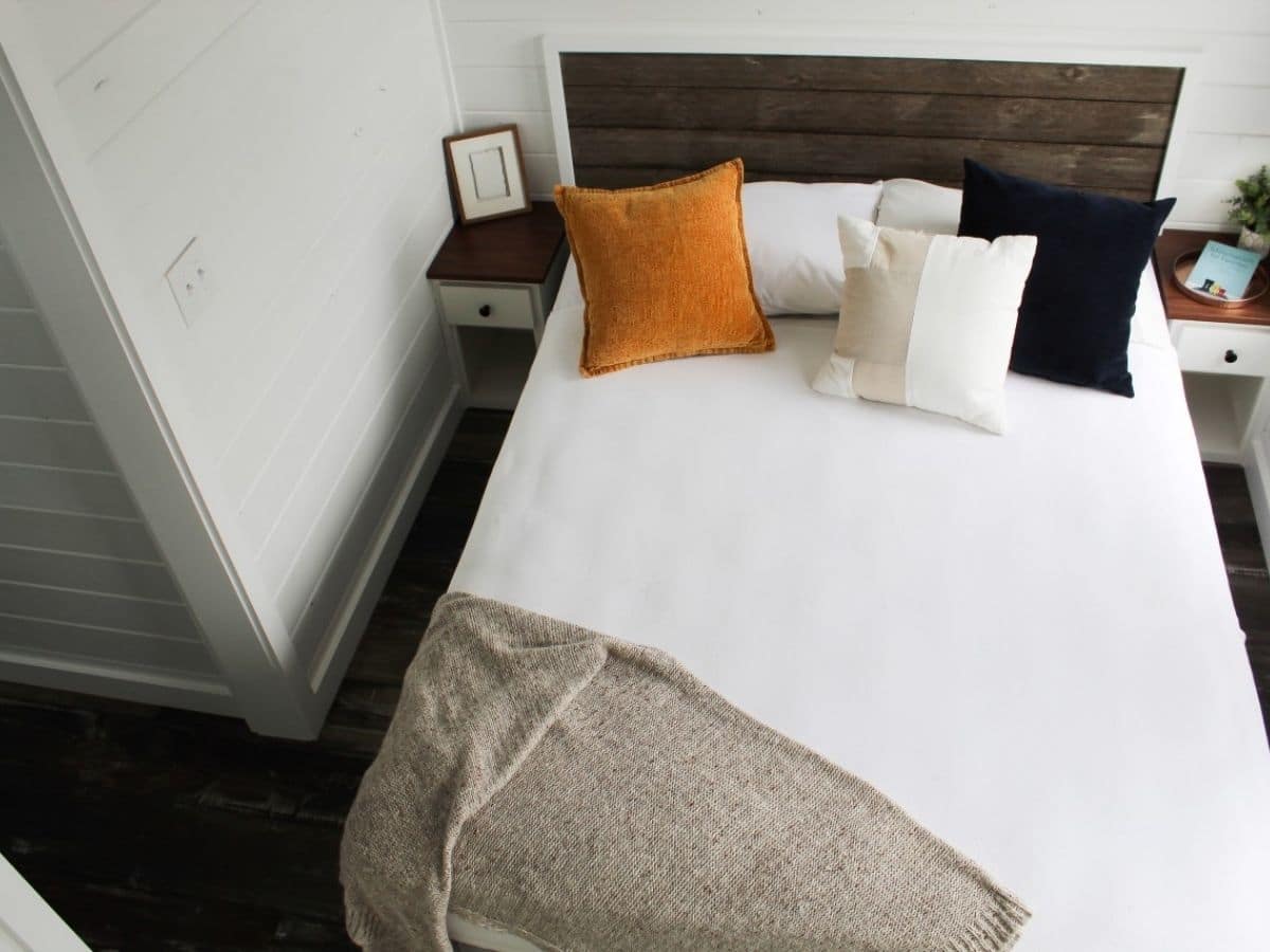bed against white wall with reclaimed wood headboard