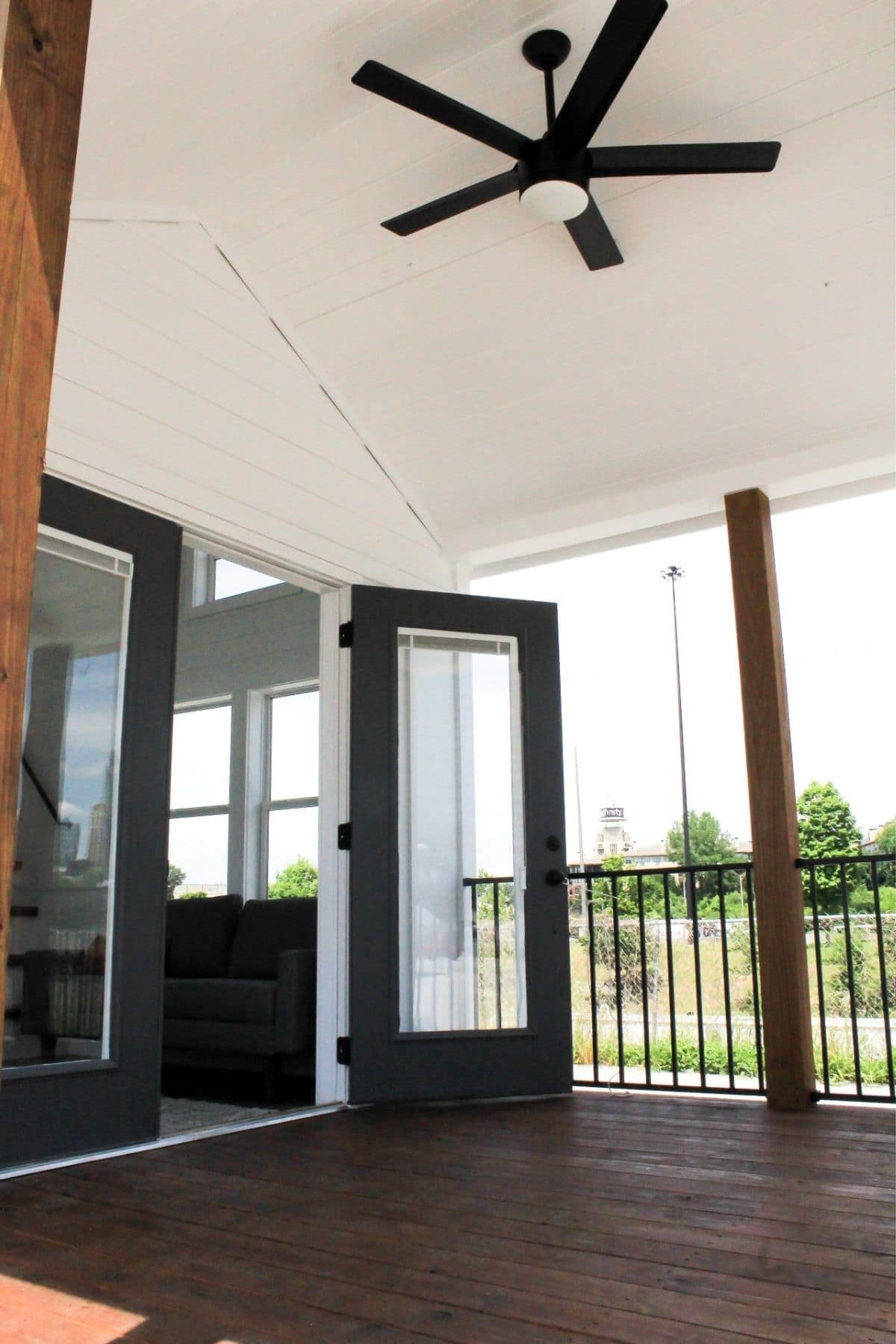 open black french door on front porch with ceiling fan on white ceiling