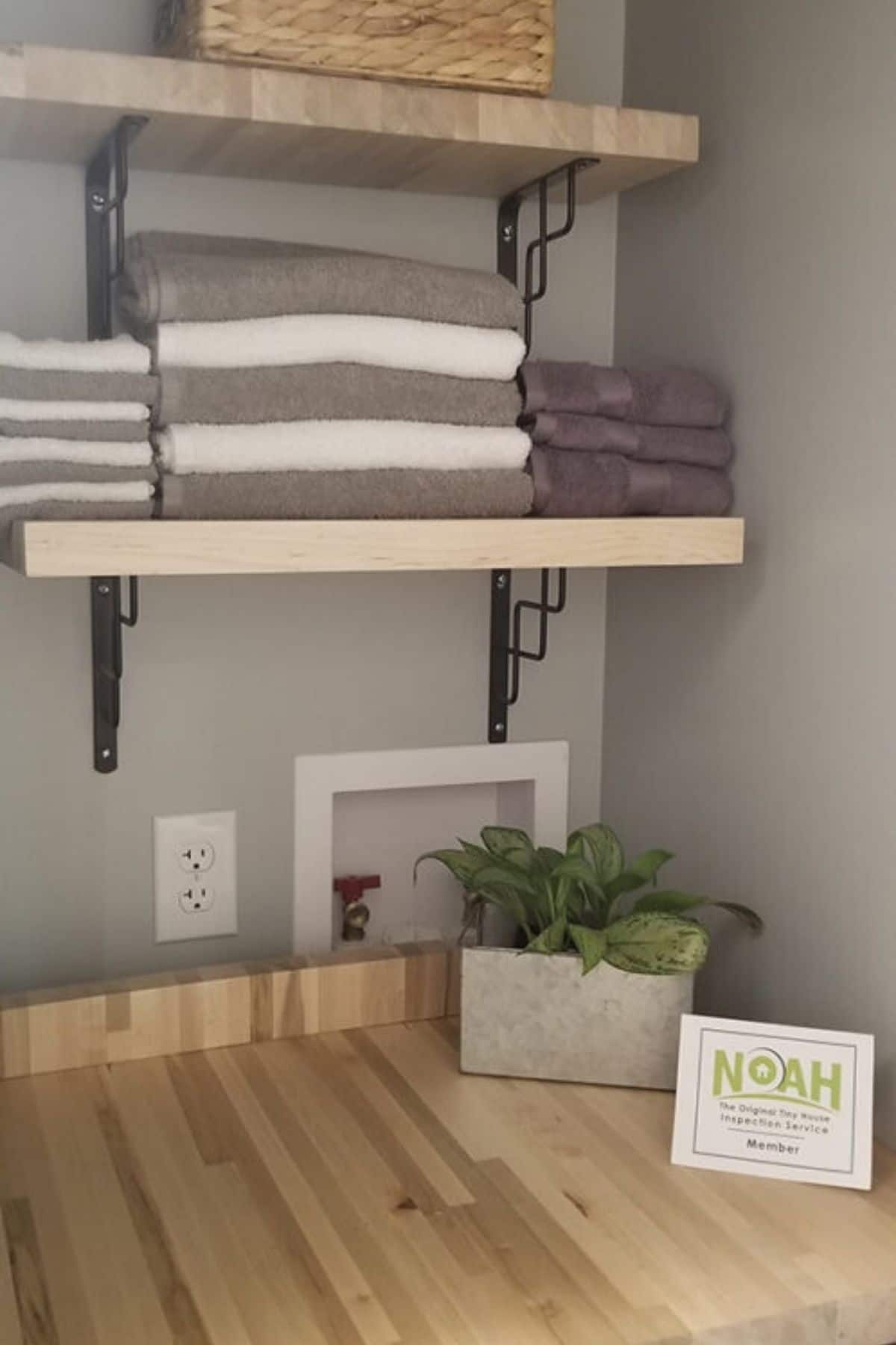 shelves above butcher block counter loaded with towels