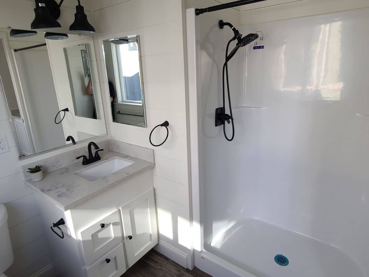 bathroom with white large shower stall vanity and mirror on wall